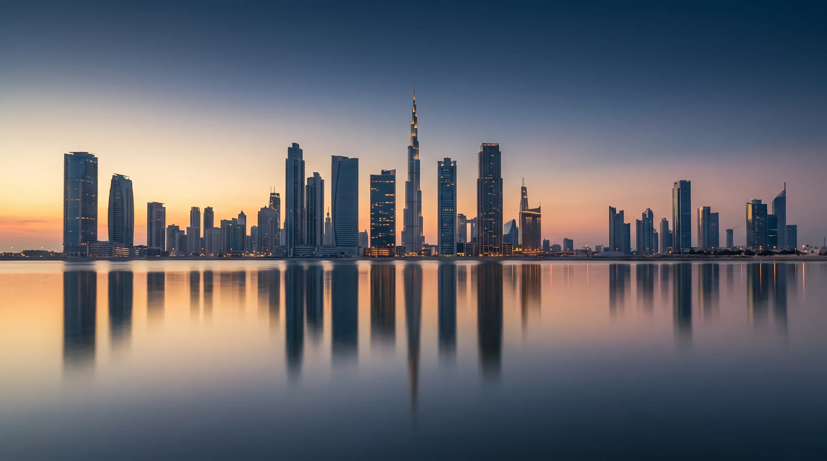 Dubai skyline at blue hour, seen across still water